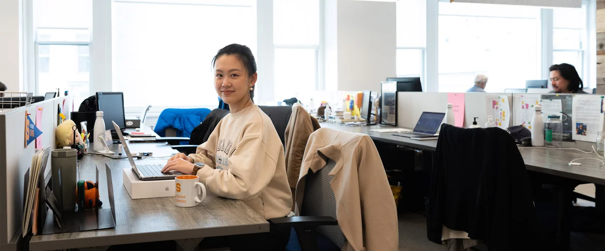 Student posing while sitting at a workspace.