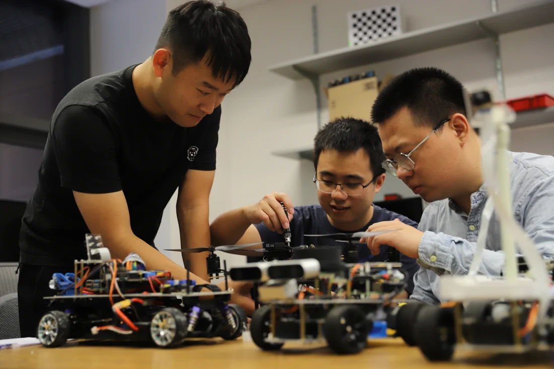 Three engineering and computer science students work on autonomous technology