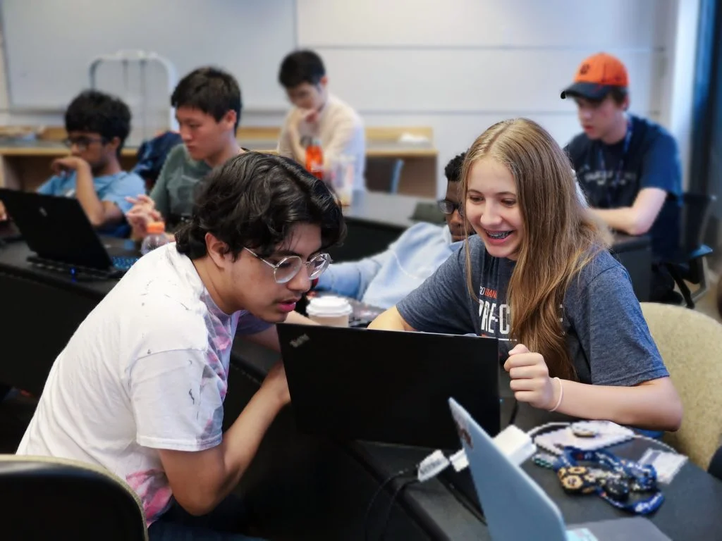Male and female students working together on laptop