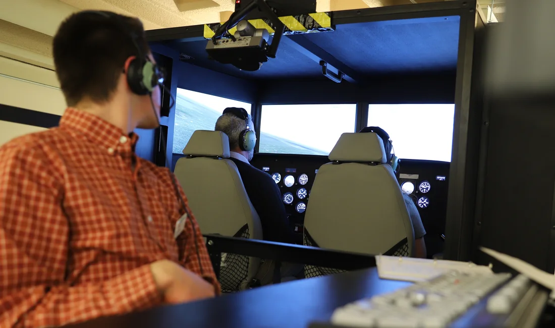 Students using Syracuse University's full motion flight simulator.