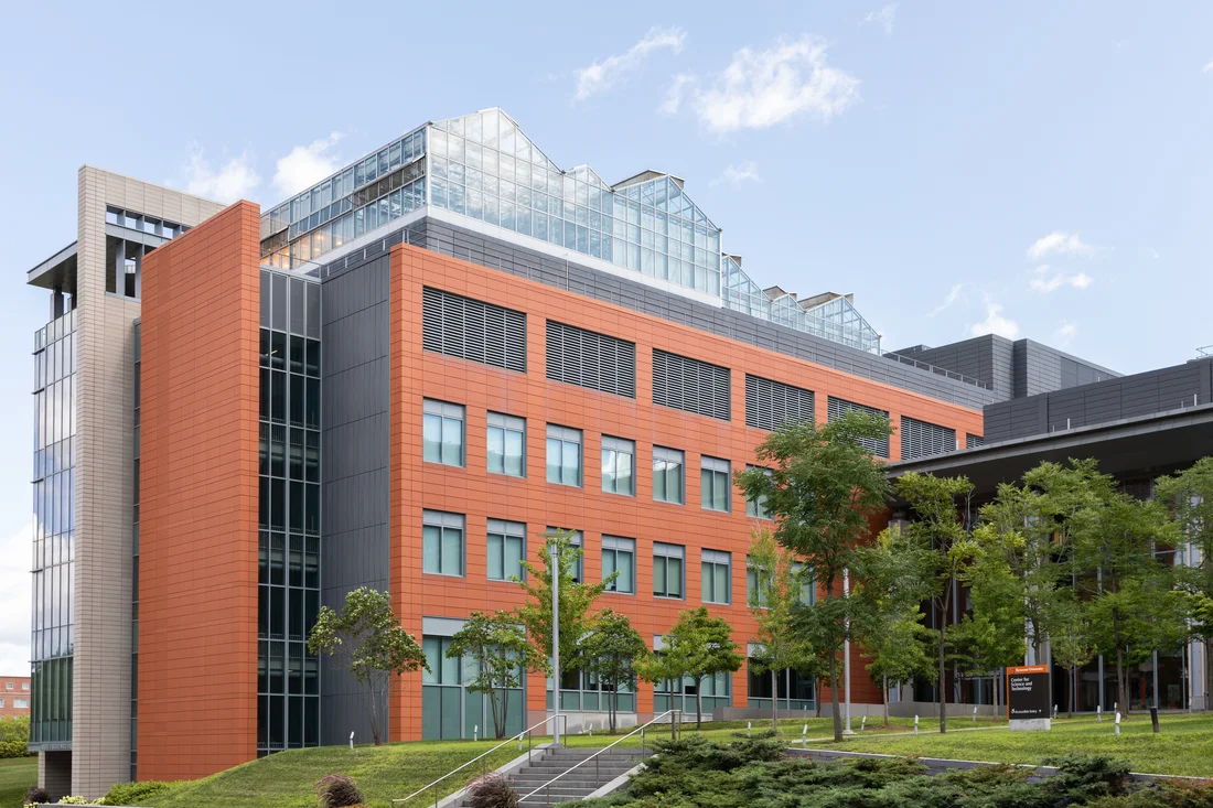 A researcher wearing gloves works at a bench.