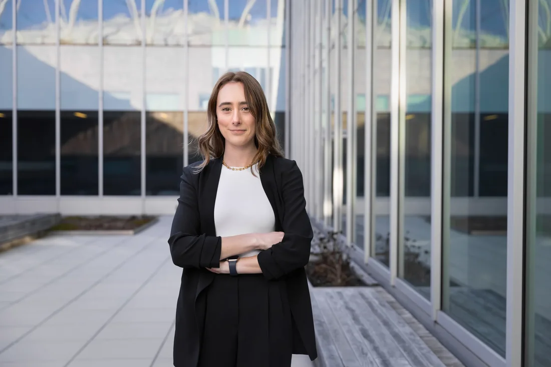 a Syracuse student wearing a suit stands outside the Whitman School of Management