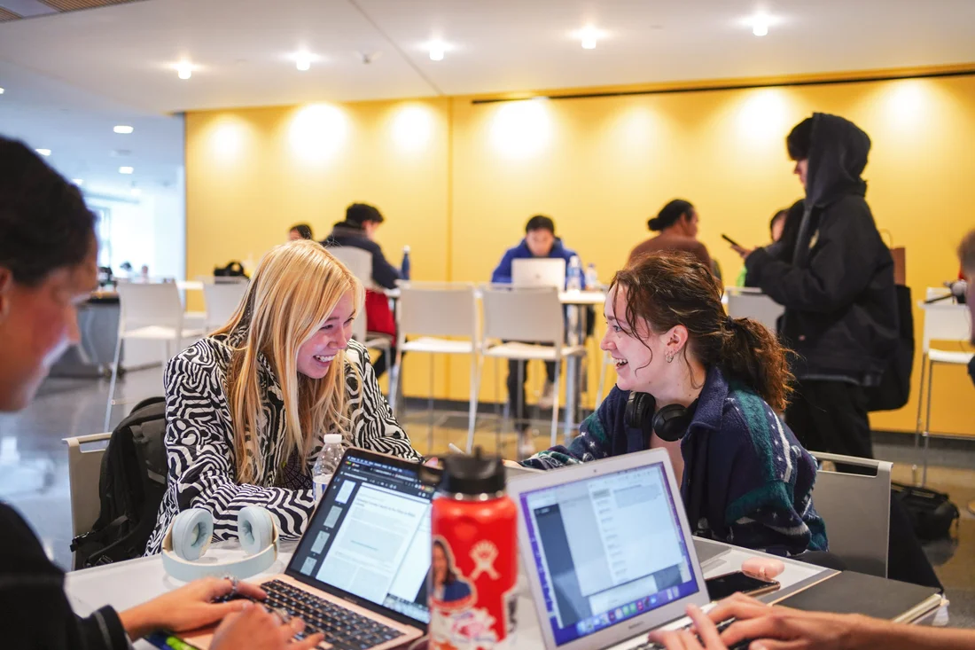 Students in the advertising program working together sitting at a table.