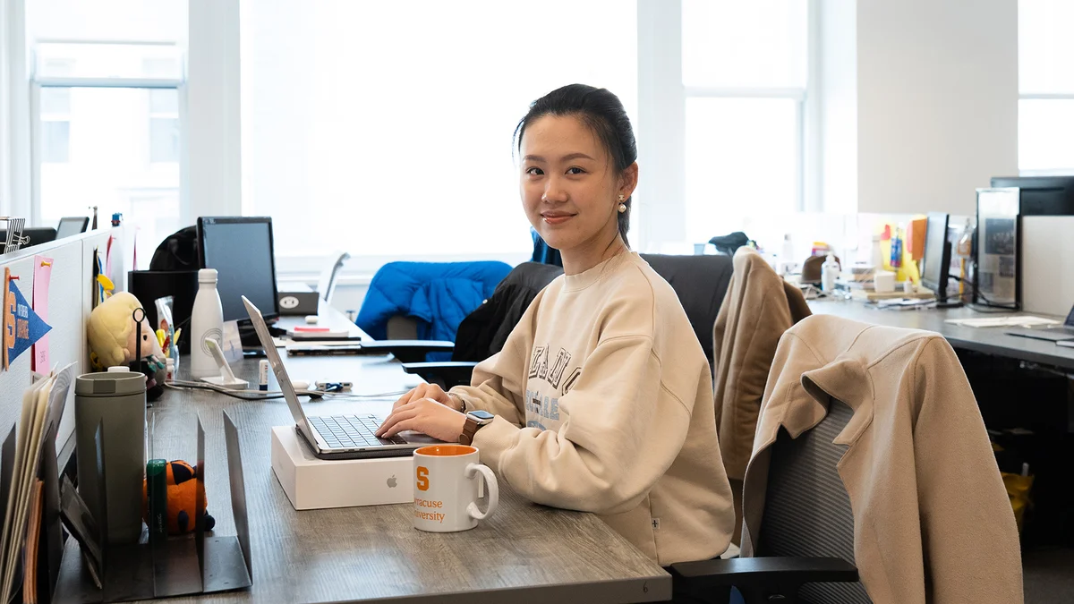 Student posing while sitting at a workspace.