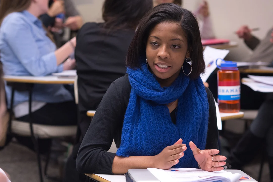 A student in the public diplomacy program working with other students in the classroom.