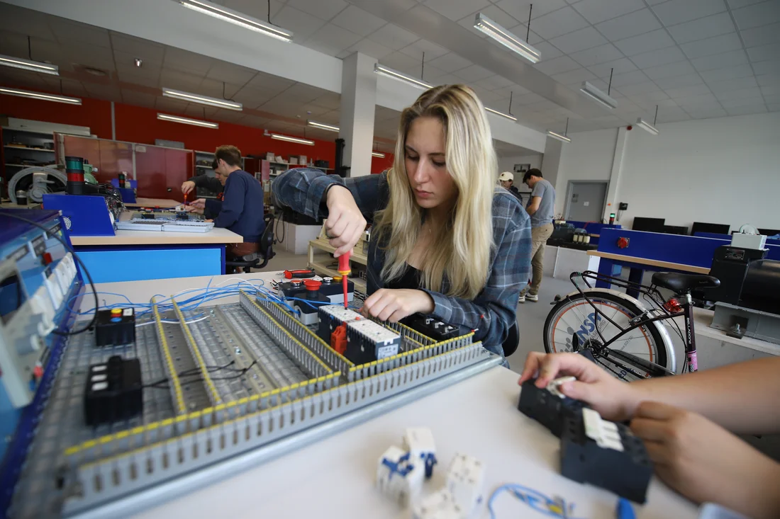 A computer engineering student using a screwdriver in a computer engineering lab